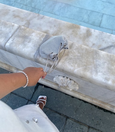 A graceful woman receiving a beautifully wrapped Golden Nova handbag in a chic boutique setting.