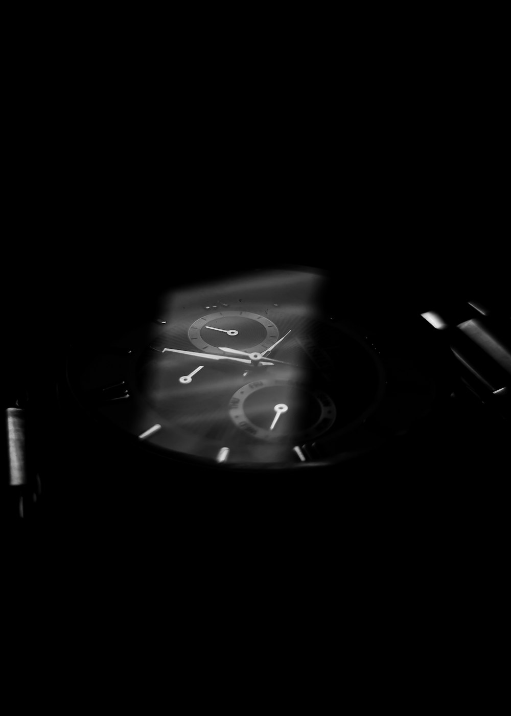 a black and white photo of a clock in the dark