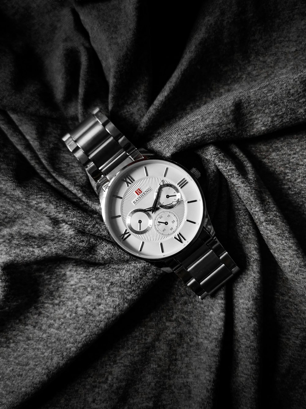 a watch is laying on a black cloth