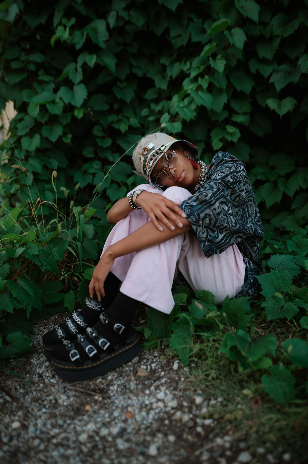 a woman sitting on the ground with her arms around her head