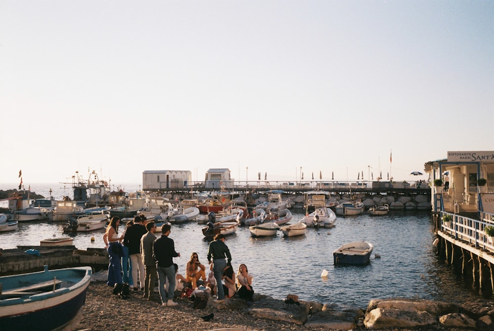 a group of people standing next to a body of water