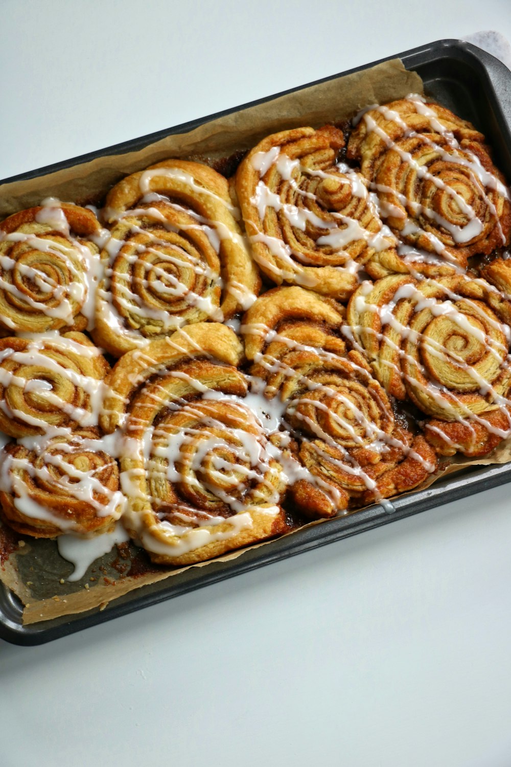 a pan filled with cinnamon rolls covered in icing