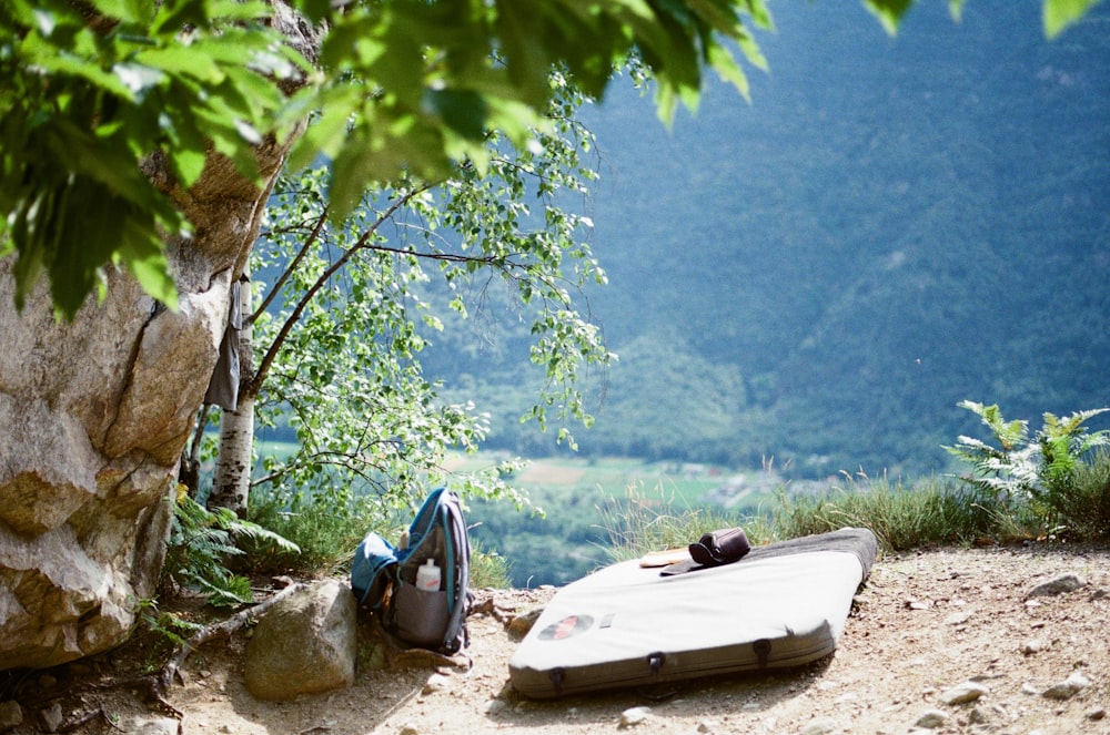 a piece of luggage sitting on top of a dirt road
