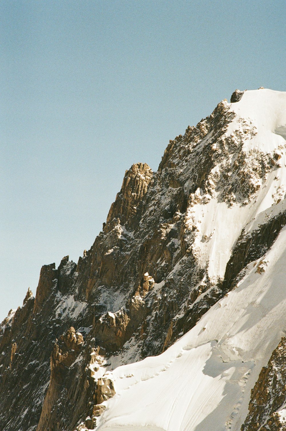 a man riding skis down the side of a snow covered mountain