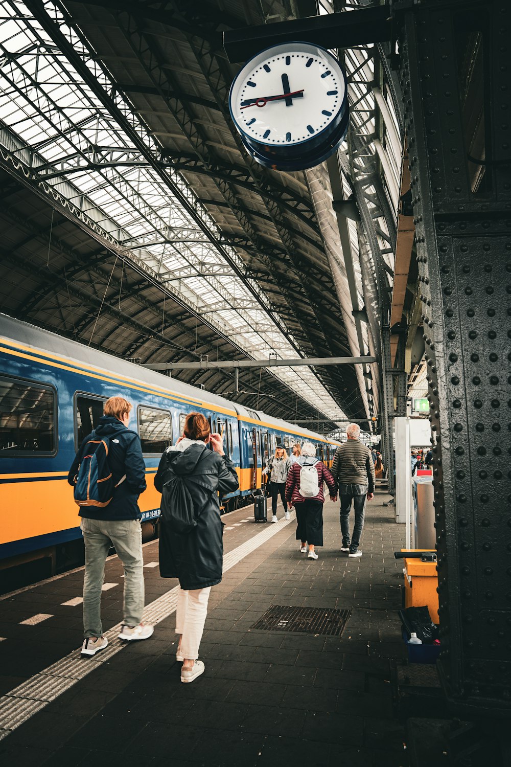 Un gruppo di persone in piedi accanto a un treno in una stazione ferroviaria