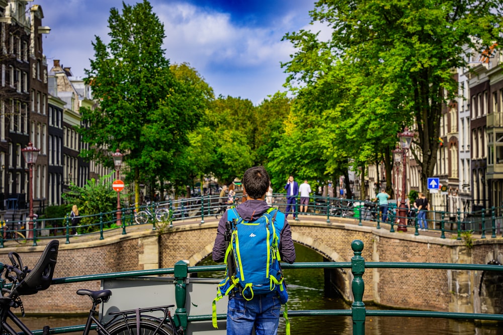 a man walking across a bridge over a river