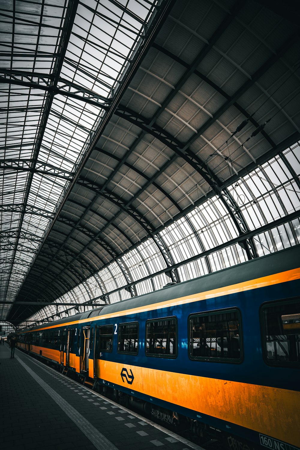 a blue and yellow train parked in a train station