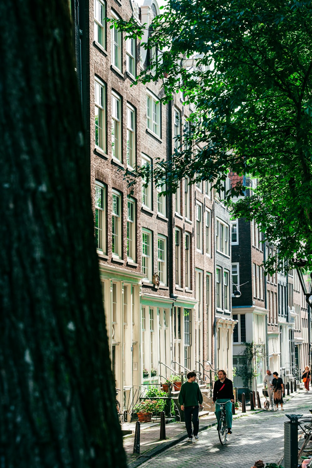 a group of people walking down a street next to tall buildings