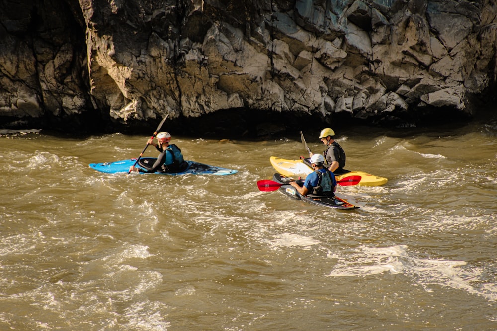 a couple of people riding kayaks on top of a river