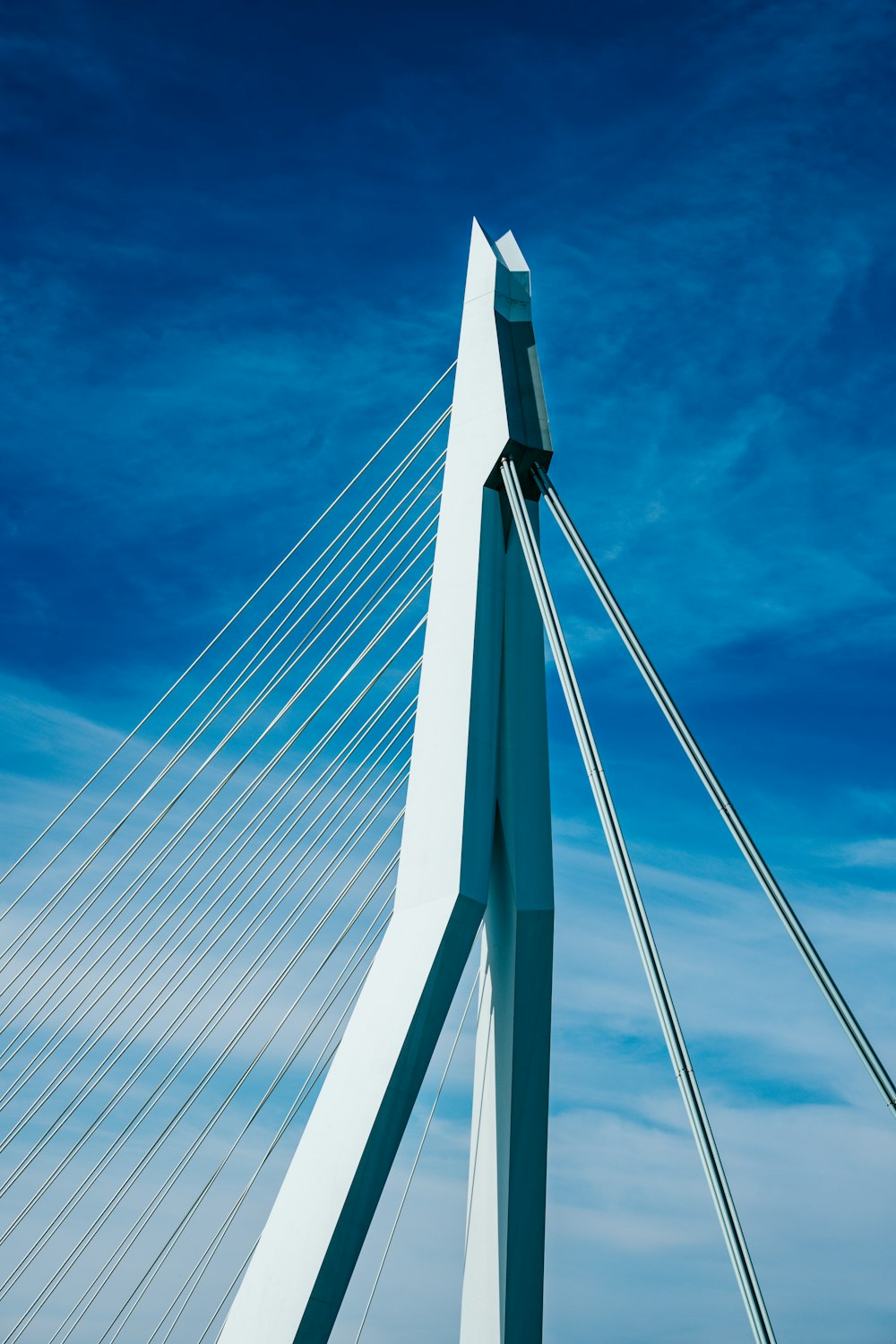 a tall white bridge with a blue sky in the background