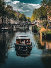 a boat traveling down a river next to a bridge
