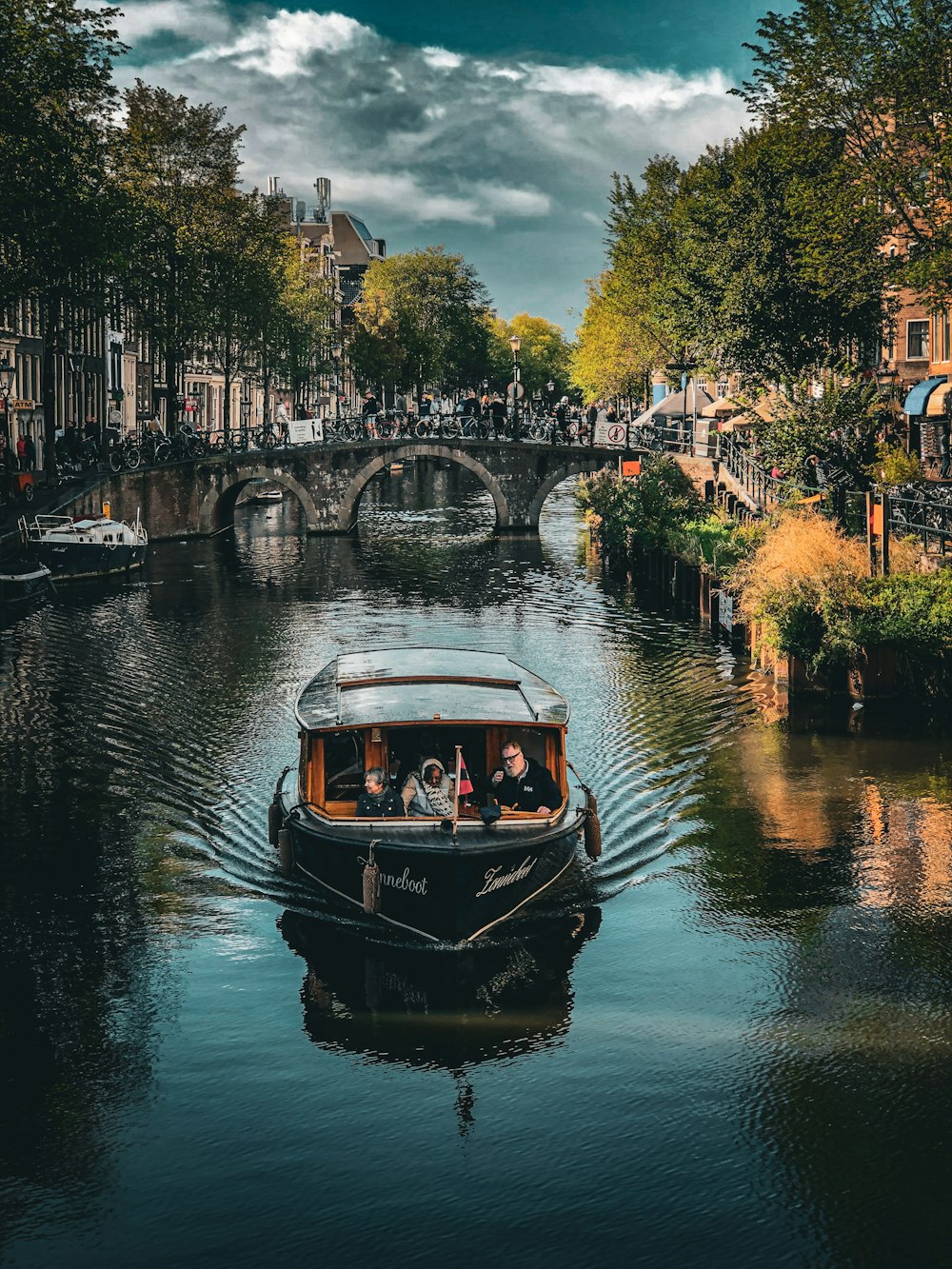 a boat traveling down a river next to a bridge