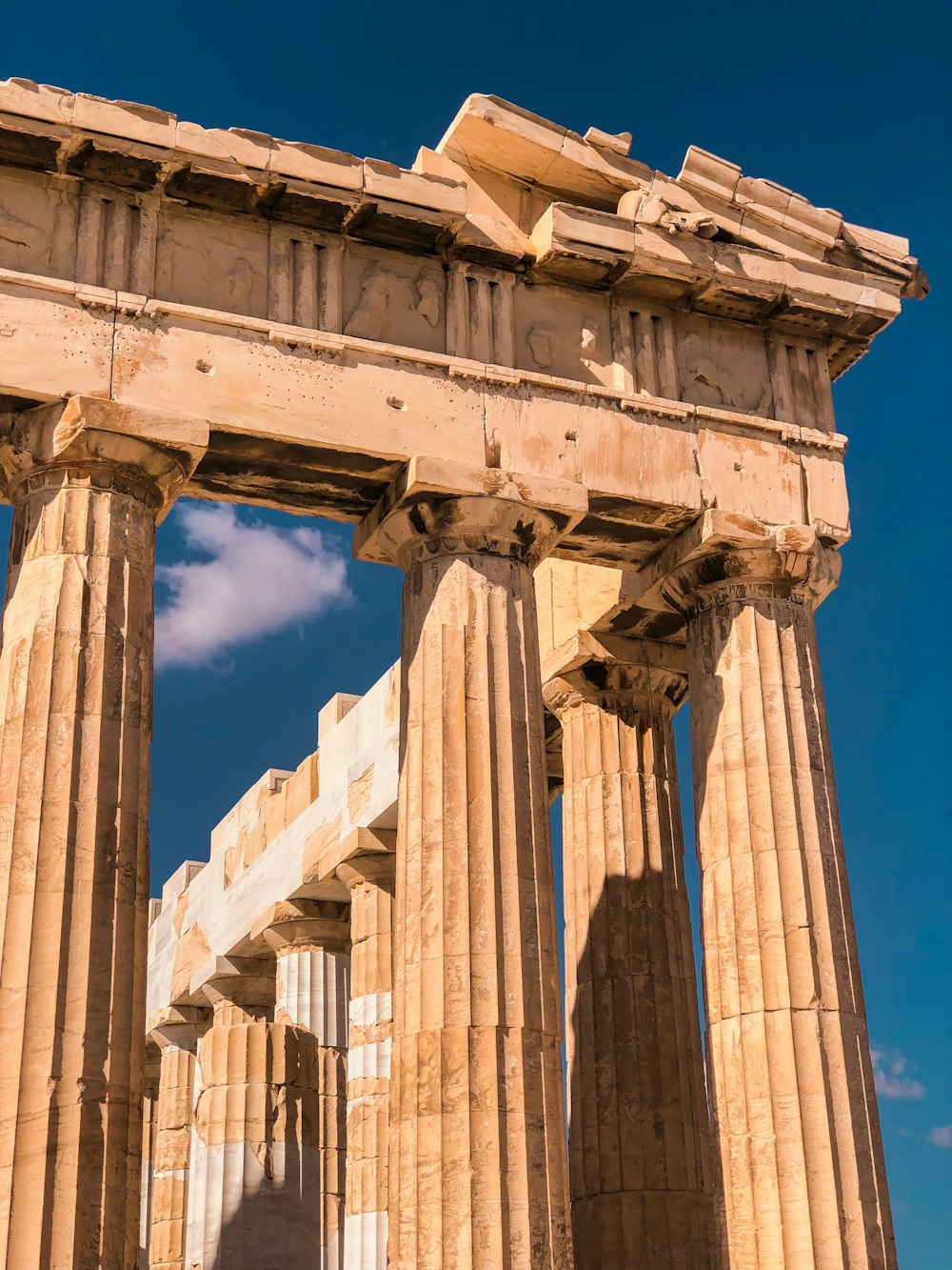 a large stone structure with columns and a sky background