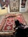 Photo of a testimonial giver inspecting a beautifully crafted rug.