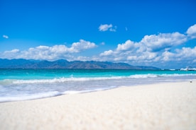 a sandy beach with a boat in the distance