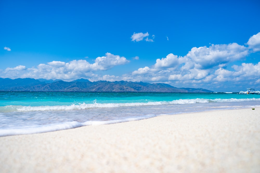 a sandy beach with a boat in the distance