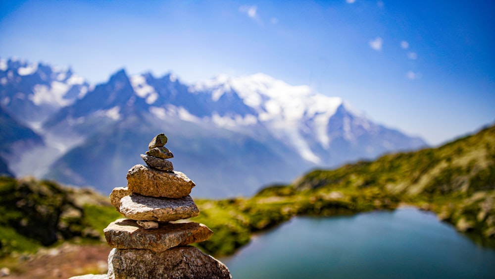 a stack of rocks sitting in front of a lake
