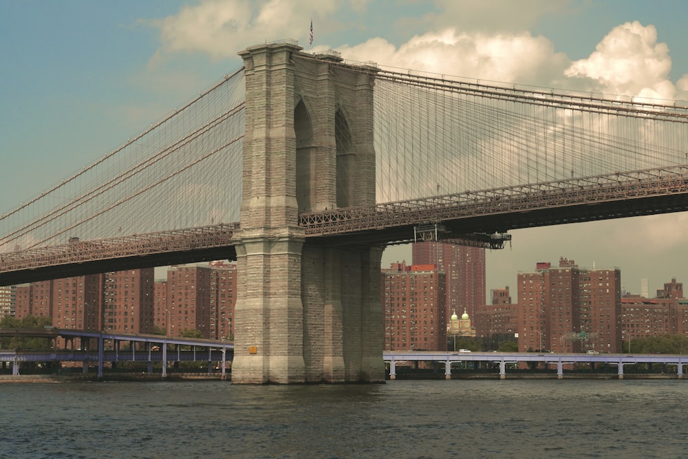 a bridge over a body of water with a city in the background