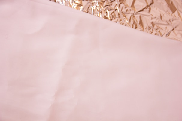 Sheets of aluminum foil partially unrolled with a reflective shine