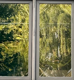 A modern two-leaf window with transparent glass showing color options from a RAL palette on the side.