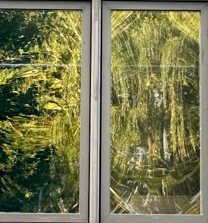 A modern two-leaf window with transparent glass showing color options from a RAL palette on the side.