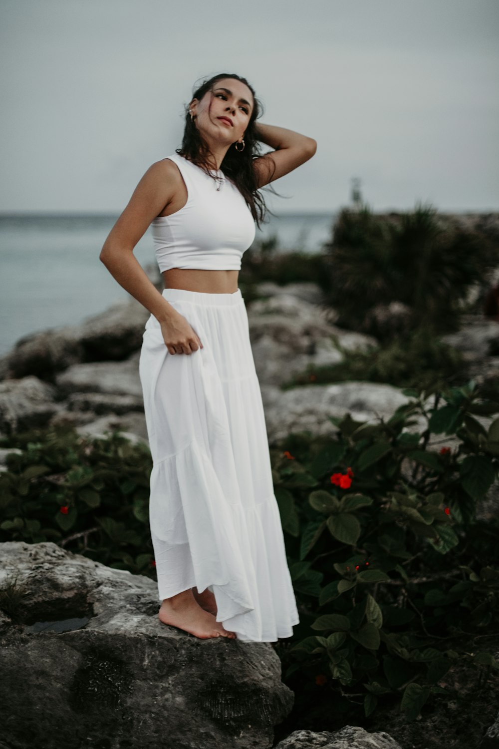 a woman standing on a rock near the ocean