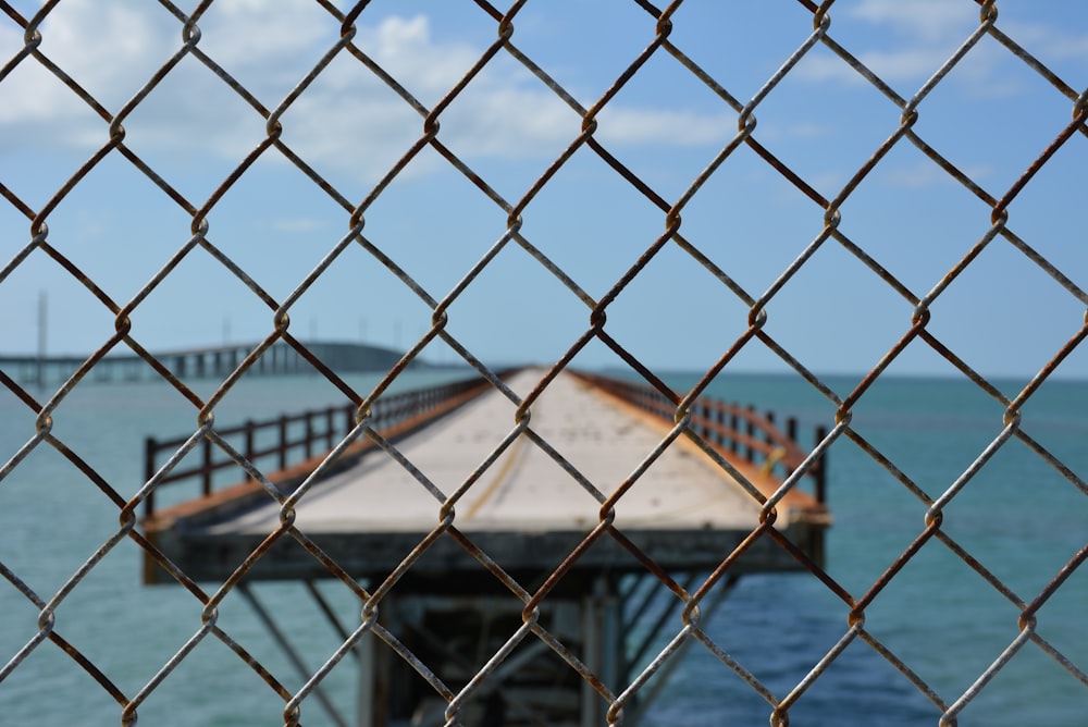 a view of a pier through a chain link fence