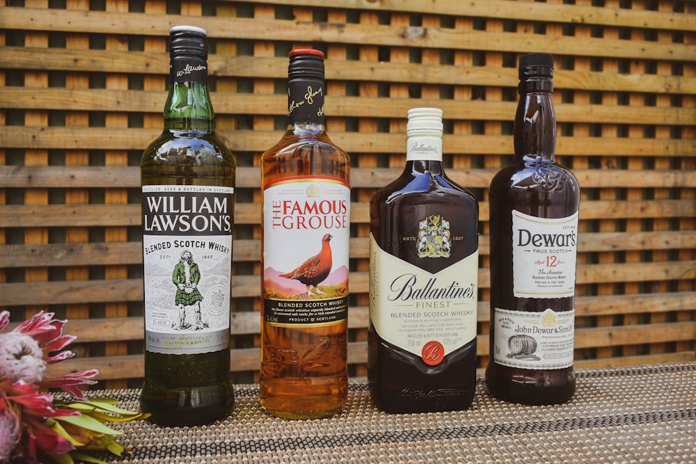 four bottles of alcohol lined up on a table