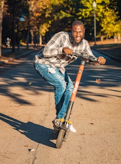 A young rider enjoying a smooth ride on a bqi electric scooty through a leafy park pathway.