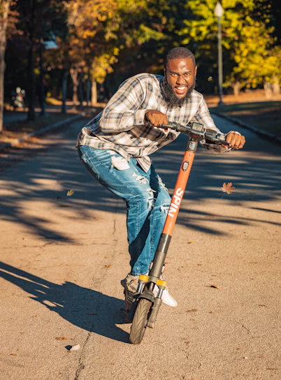 A colorful mini-cruiser gliding smoothly along a tree-lined park path in autumn.