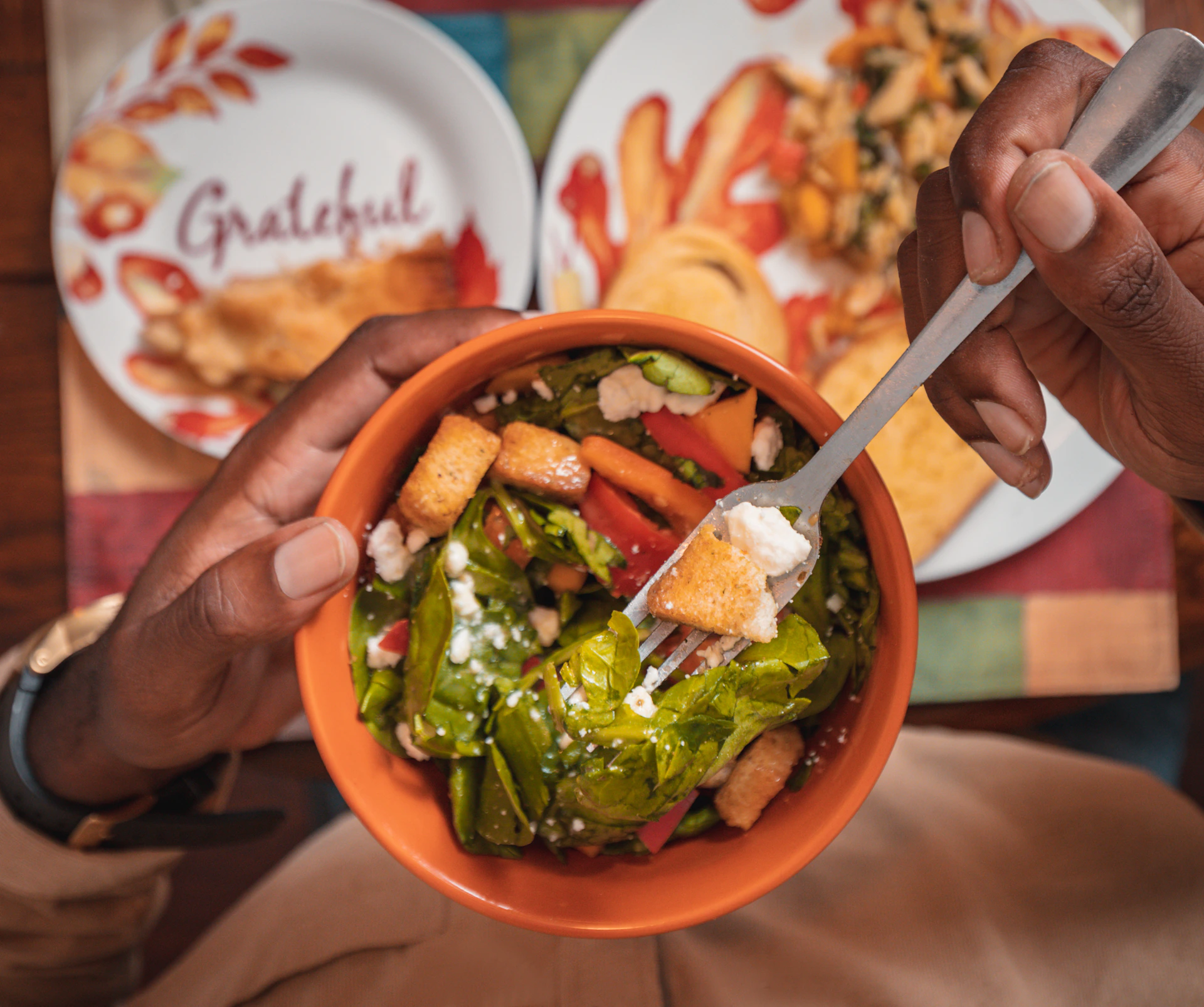 a person holding a fork in a bowl of food
