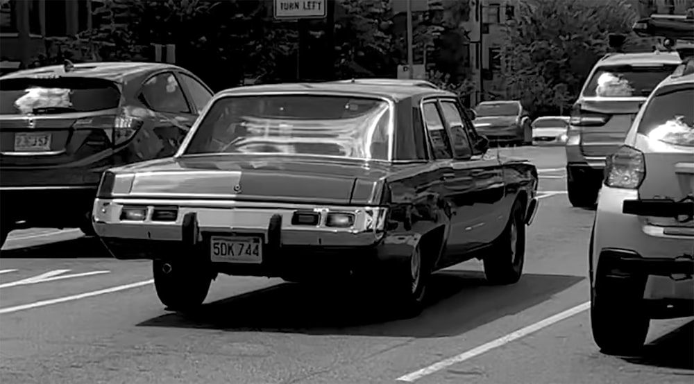 a black and white photo of cars on a city street