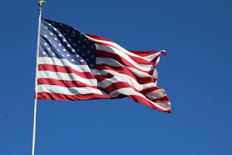 a large american flag flying high in the sky