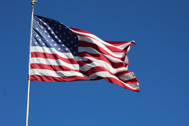 a large american flag flying high in the sky