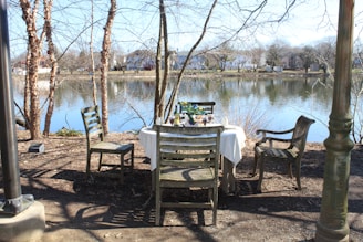 A rustic dining setup by the tranquil backwaters of Yagachi reservoir at sunset.