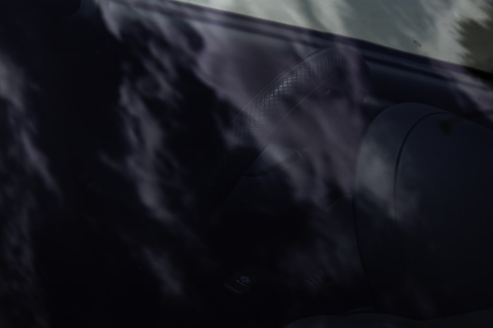 a close up of a car window with clouds in the background