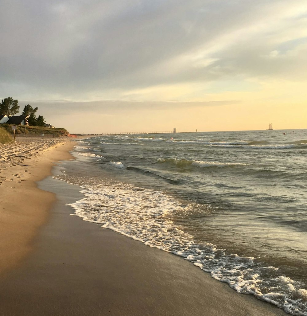 a sandy beach with waves coming in to shore