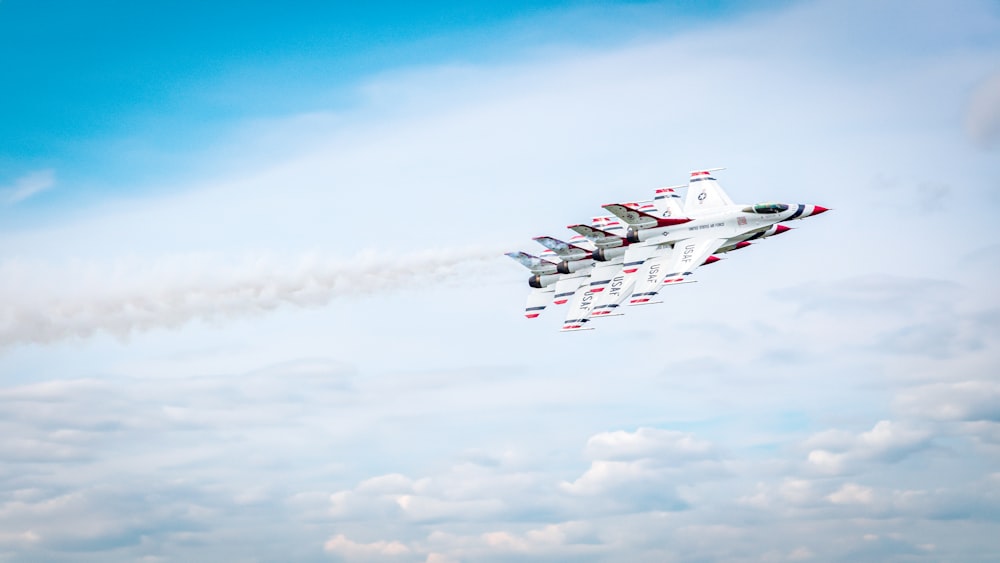 a group of fighter jets flying through a blue sky