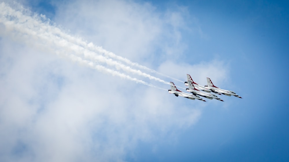 a group of fighter jets flying through a blue sky