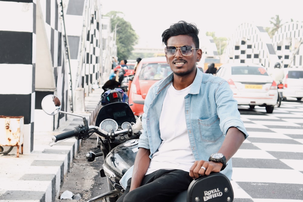 a man sitting on a motorcycle in the middle of a street