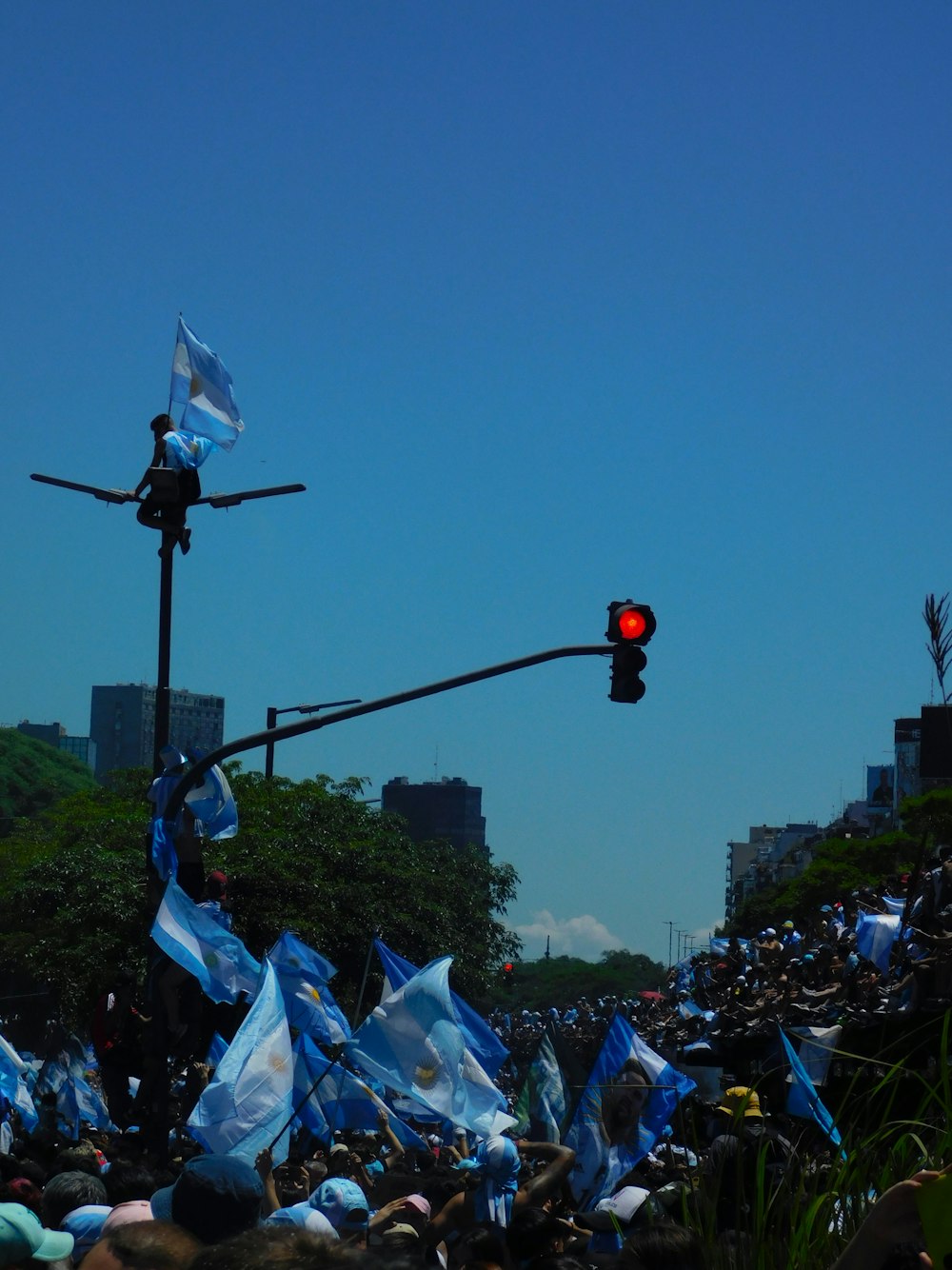 a crowd of people standing around a traffic light