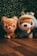 Two plush toys resembling dogs are placed side by side on a wooden floor with a backdrop of green foliage. The toy on the left has a simple design with a happy expression and a protruding tongue, while the one on the right wears a blue costume with a duck-bill hood.