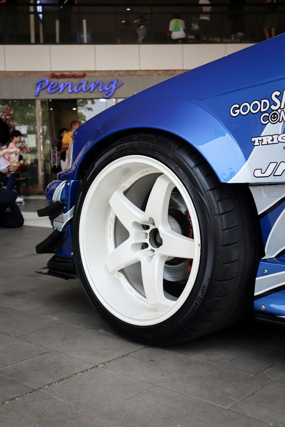 a close up of a blue car with white wheels