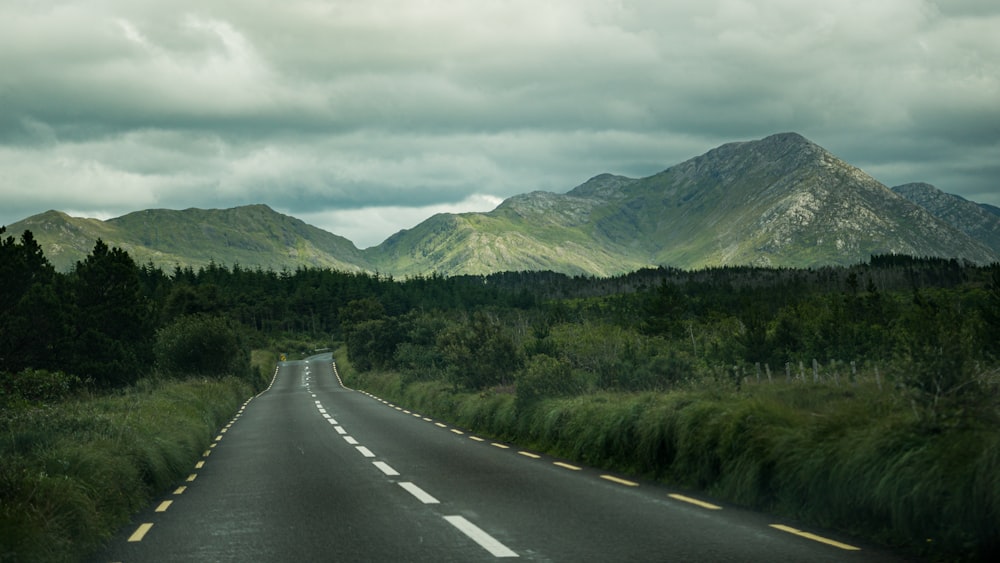 a long road with mountains in the background