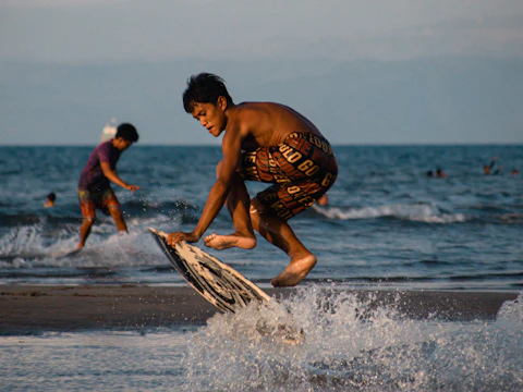 Close-up of skimboarders gliding smoothly over shallow water in a city plaza.
