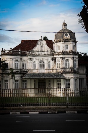a large white building sitting on the side of a road