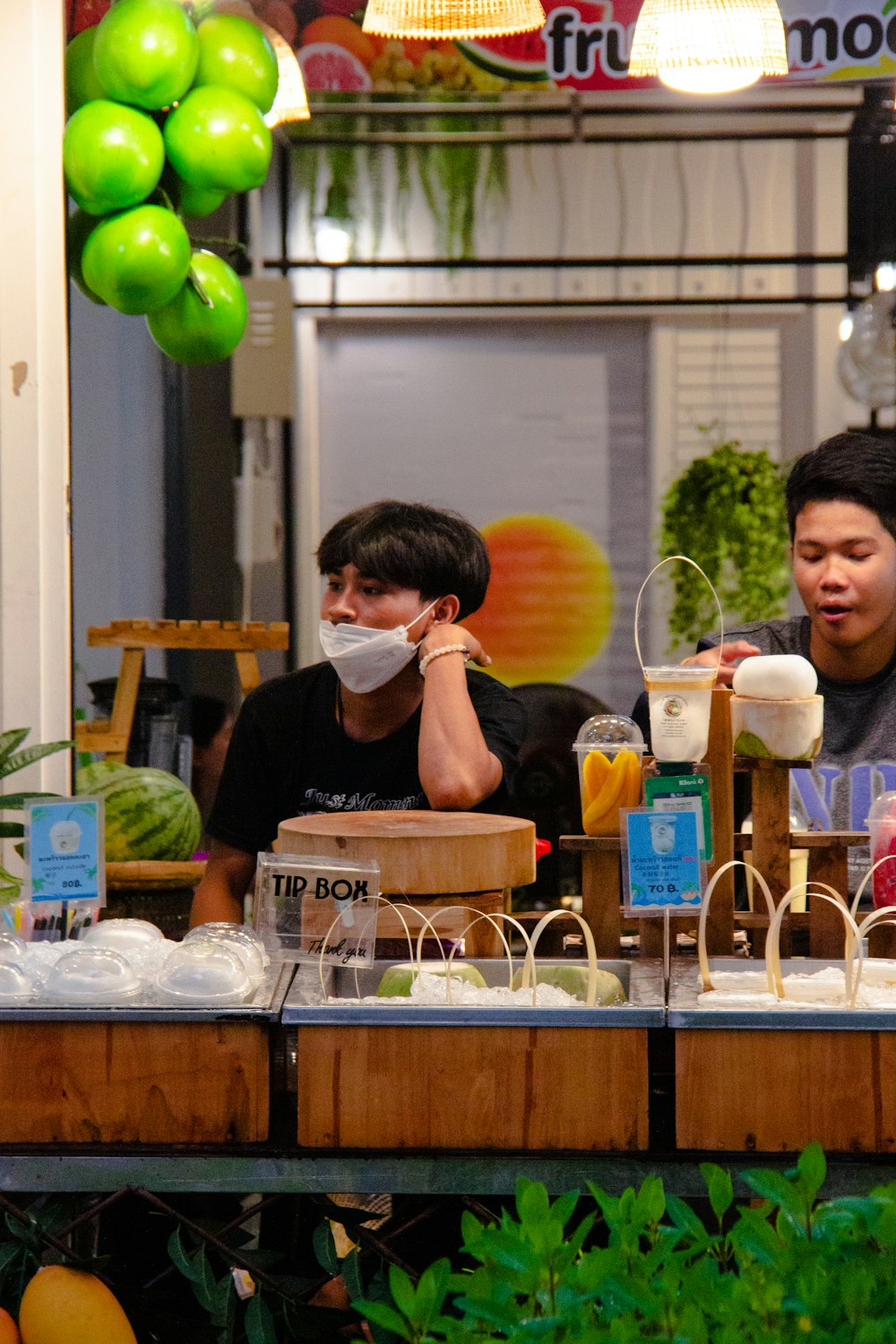 a couple of people standing at a counter with food