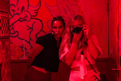 Guests laughing and posing in front of the Magic Mirror with instant photo prints.