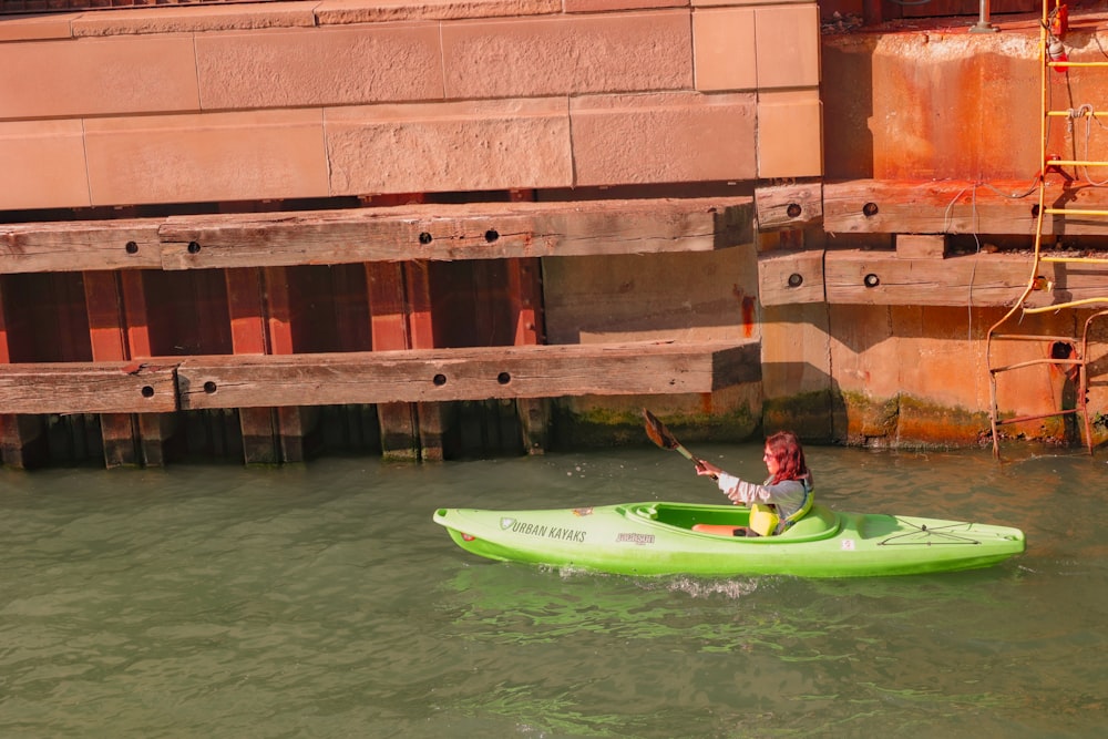 a person in a green kayak in a body of water