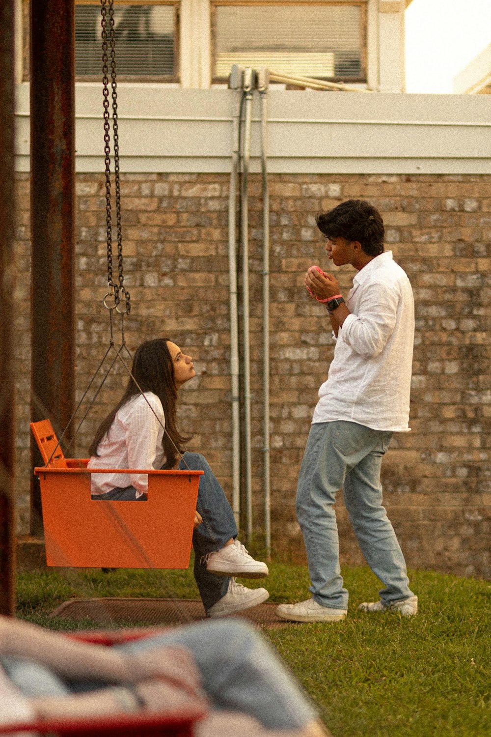 a woman sitting on a bench next to a man